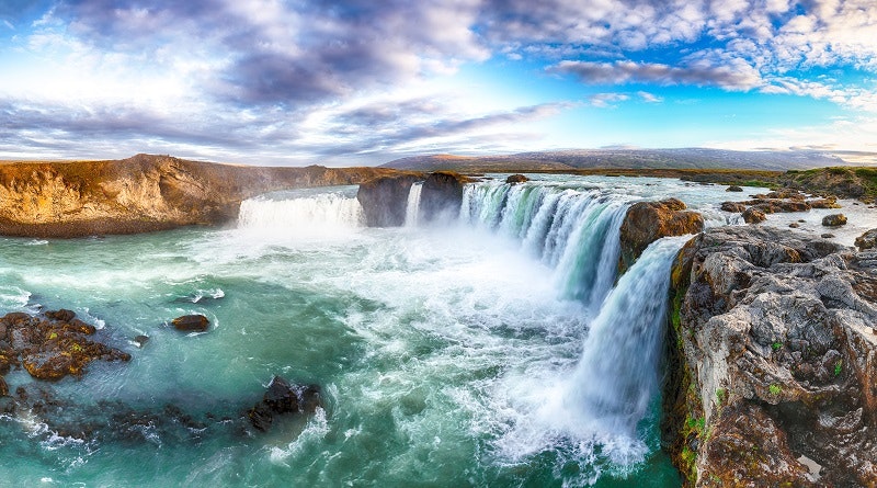 A waterfall in Iceland with blue skies